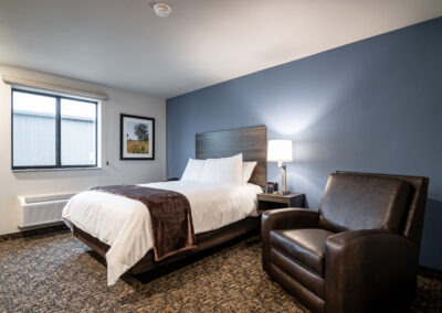 One bed hotel room with chair